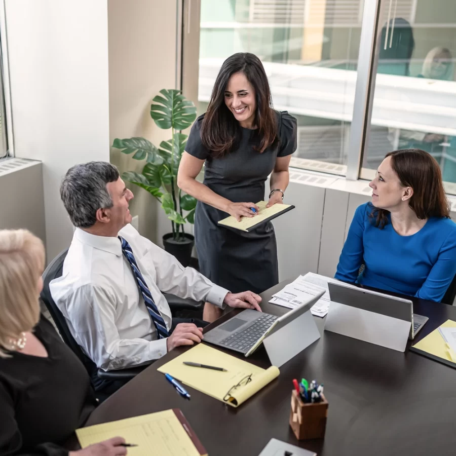 Birds eye view of four staff members in the conference room.